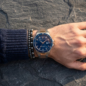 Close up of Maserati Sfida R8853140003 men's quartz battery watch on wrist showing blue sunray dial and two-tone metal bracelet