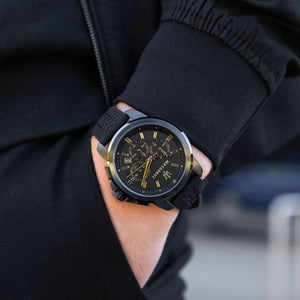 Male model wearing Maserati Successo R8871621011 black and gold watch with a sporty casual outfit