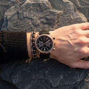 Close up of Maserati Legend R8871638001 men's quartz battery watch on wrist showing black chronograph dial and bronze-tone case