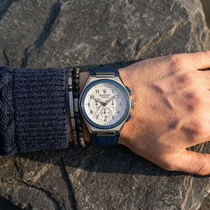 Close up of Maserati Triconic R8871639001 men's quartz battery watch on wrist showing white striped dial and blue rubber strap