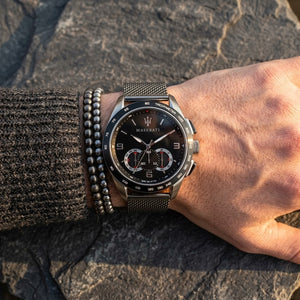 Close up of Maserati Traguardo R8873612031 men's quartz battery watch on wrist showing black sunray dial and black mesh metal strap