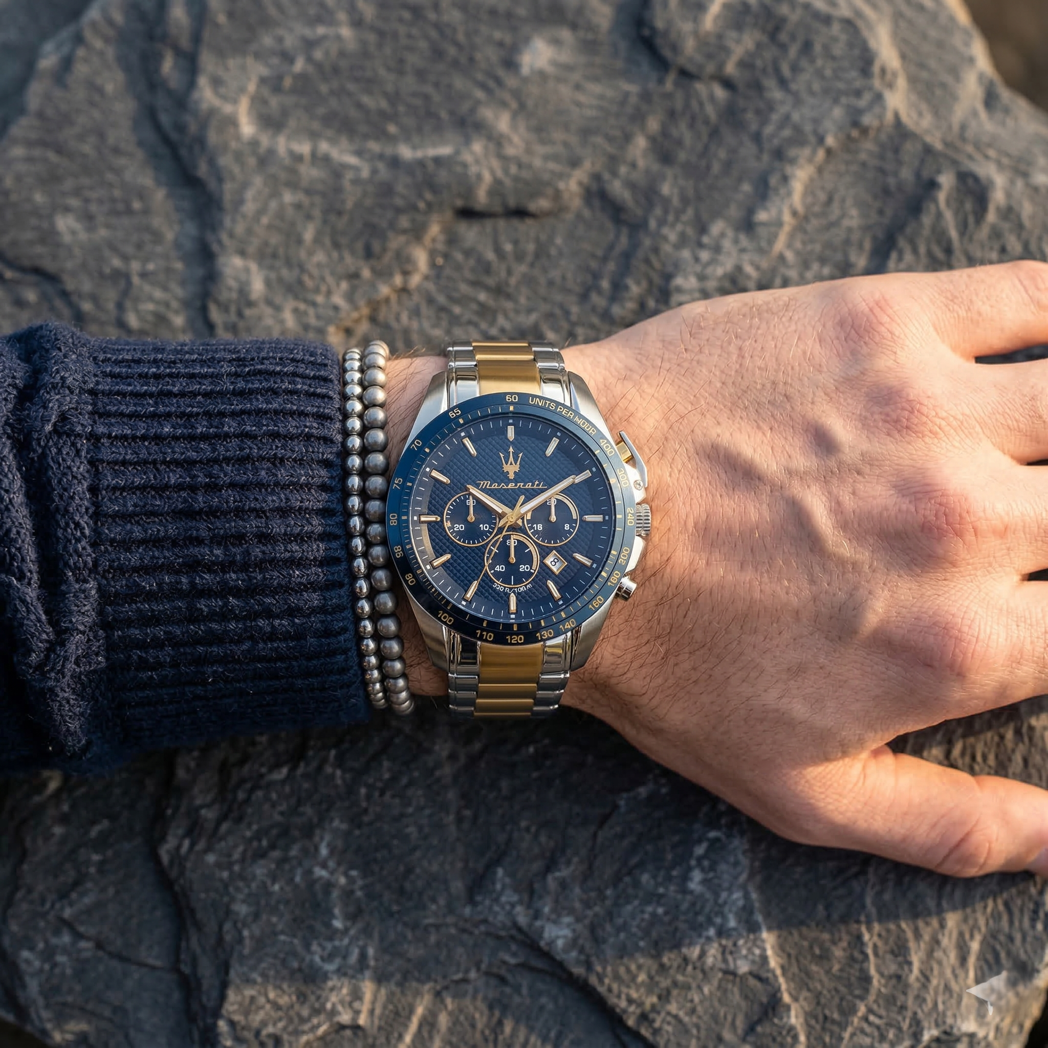 Close up of Maserati Traguardo R8873612046 men's quartz battery watch on wrist showing blue chronograph dial and two-tone metal bracelet