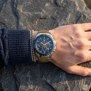 Close up of Maserati Traguardo R8873612046 men's quartz battery watch on wrist showing blue chronograph dial and two-tone metal bracelet