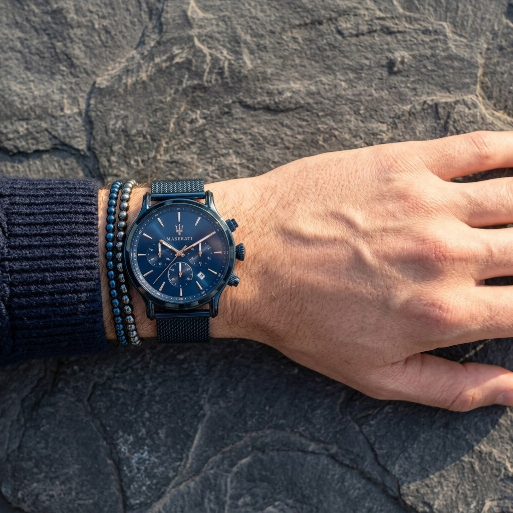 Close up of Maserati Epoca R8873618010 men's quartz battery watch on wrist showing blue sunray dial and blue mesh metal strap