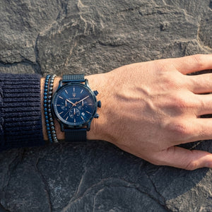 Close up of Maserati Epoca R8873618010 men's quartz battery watch on wrist showing blue sunray dial and blue mesh metal strap