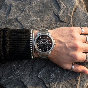 Close up of Maserati Successo R8873621001 men's quartz battery watch on wrist showing black dial and silver metal bracelet