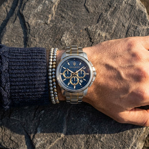 Close up of Maserati Successo R8873621016 men's quartz battery watch on wrist showing blue dial and two-tone metal bracelet