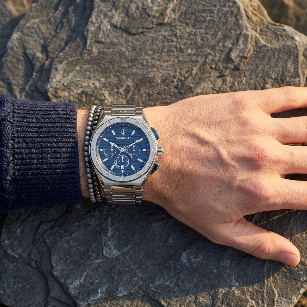 Close up of Maserati Triconic R8873639001 men's quartz battery watch on wrist showing blue striped dial and integrated silver metal bracelet
