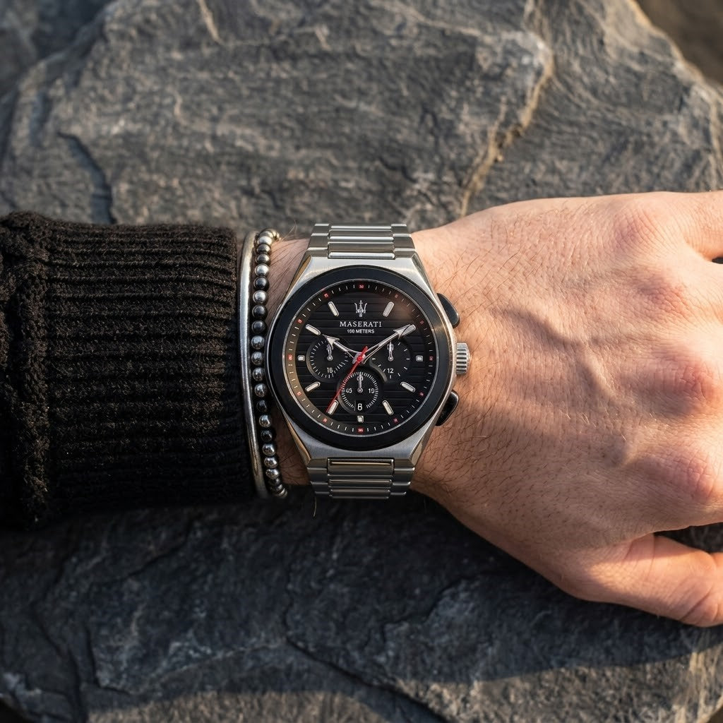 Close up of Maserati Triconic R8873639002 men's quartz battery watch on wrist showing black striped dial and silver metal bracelet