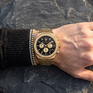 Close up of Maserati Stile Chronograph R8873642001 men's quartz battery watch on wrist showing black dial and luxury gold chronograph sub-dials