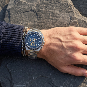 Close up of Maserati Velocita R8873652001 men's quartz battery watch on wrist showing blue racing dial and silver metal bracelet