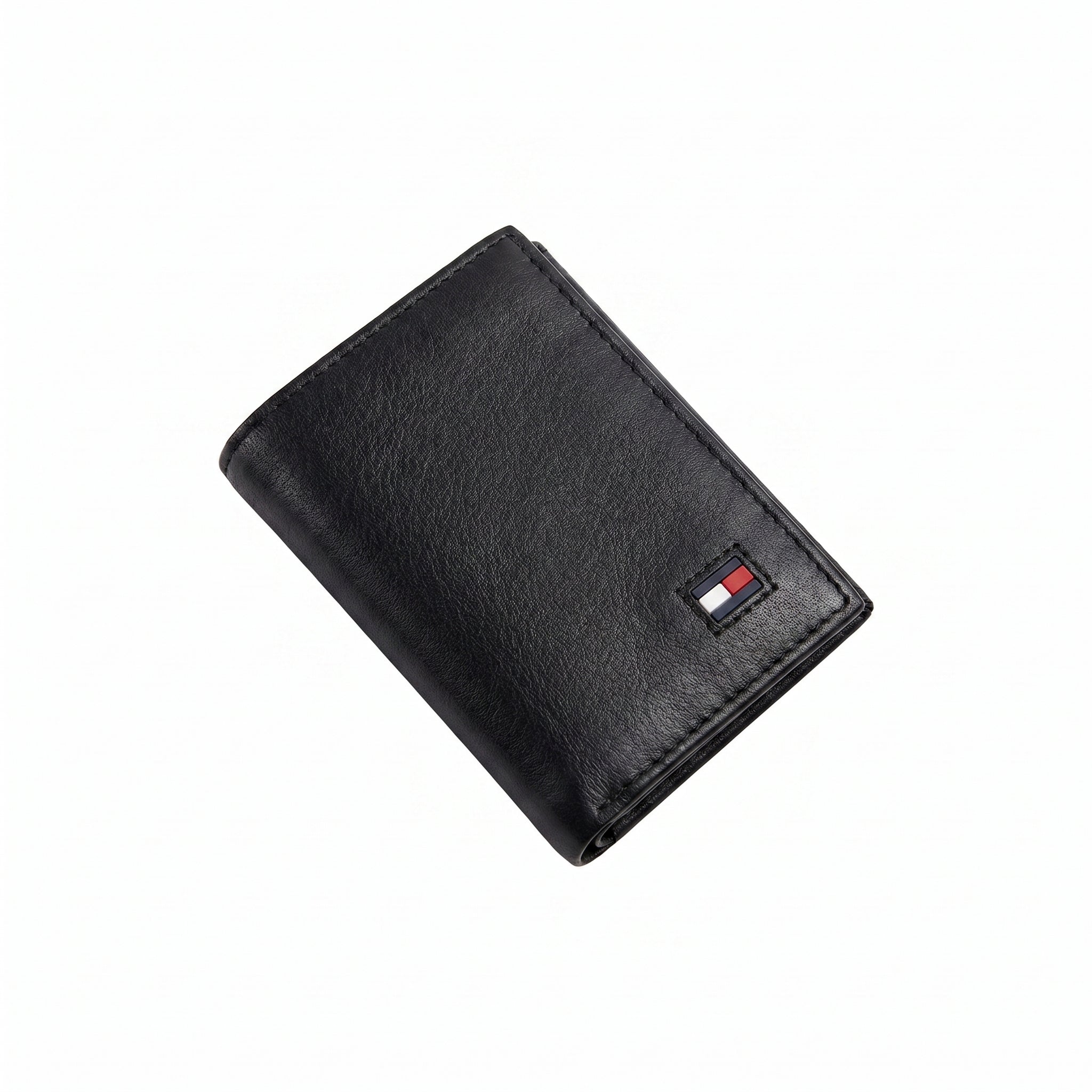 Front studio view of the Tommy Hilfiger black trifold wallet showing the premium grained leather texture and small enamel flag logo