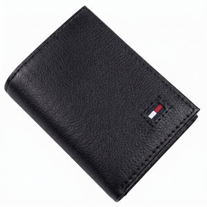 Front studio view of the Tommy Hilfiger black trifold wallet showing the premium grained leather texture and small enamel flag logo