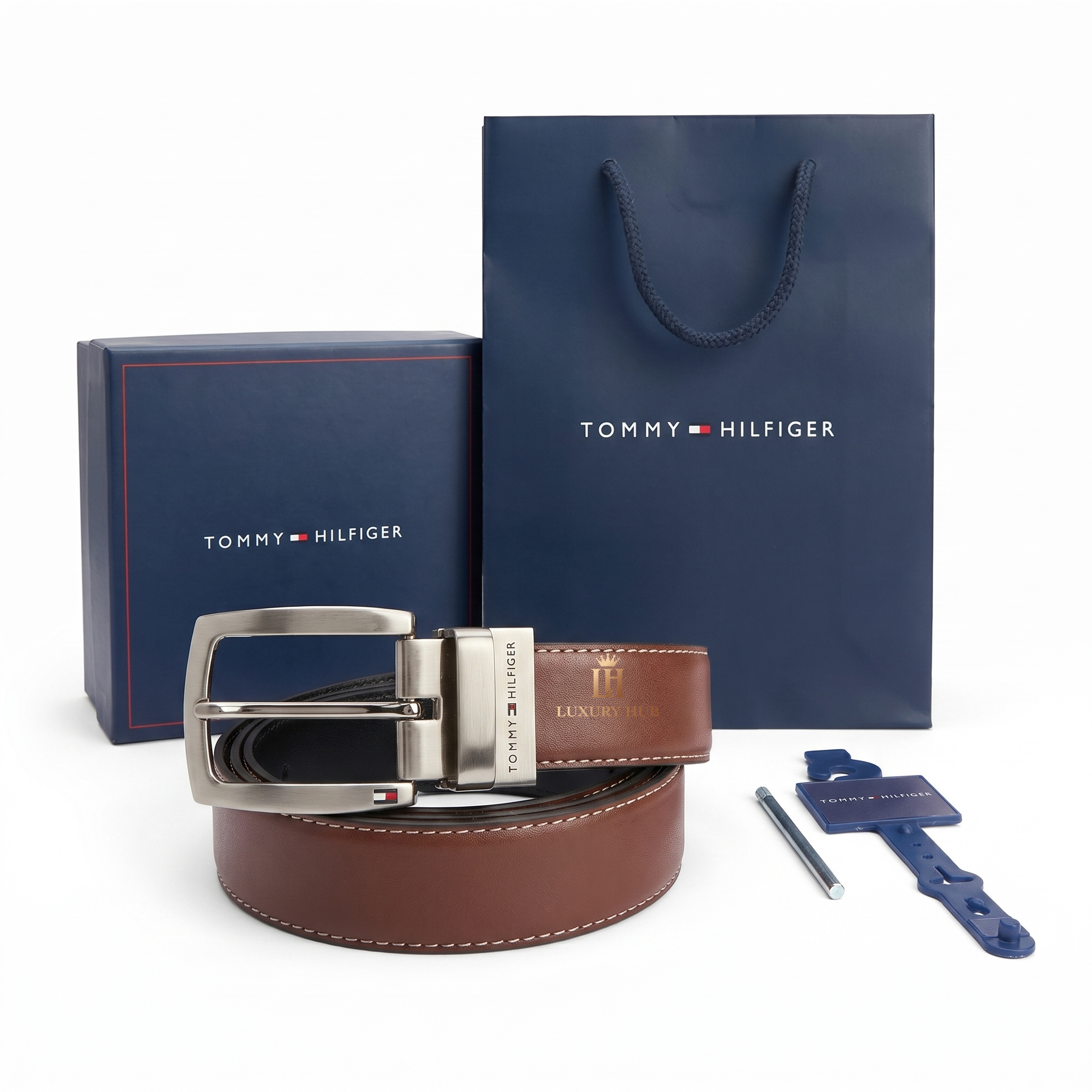 Tommy Hilfiger brown belt with silver buckle, packaging, and care card on a white background
