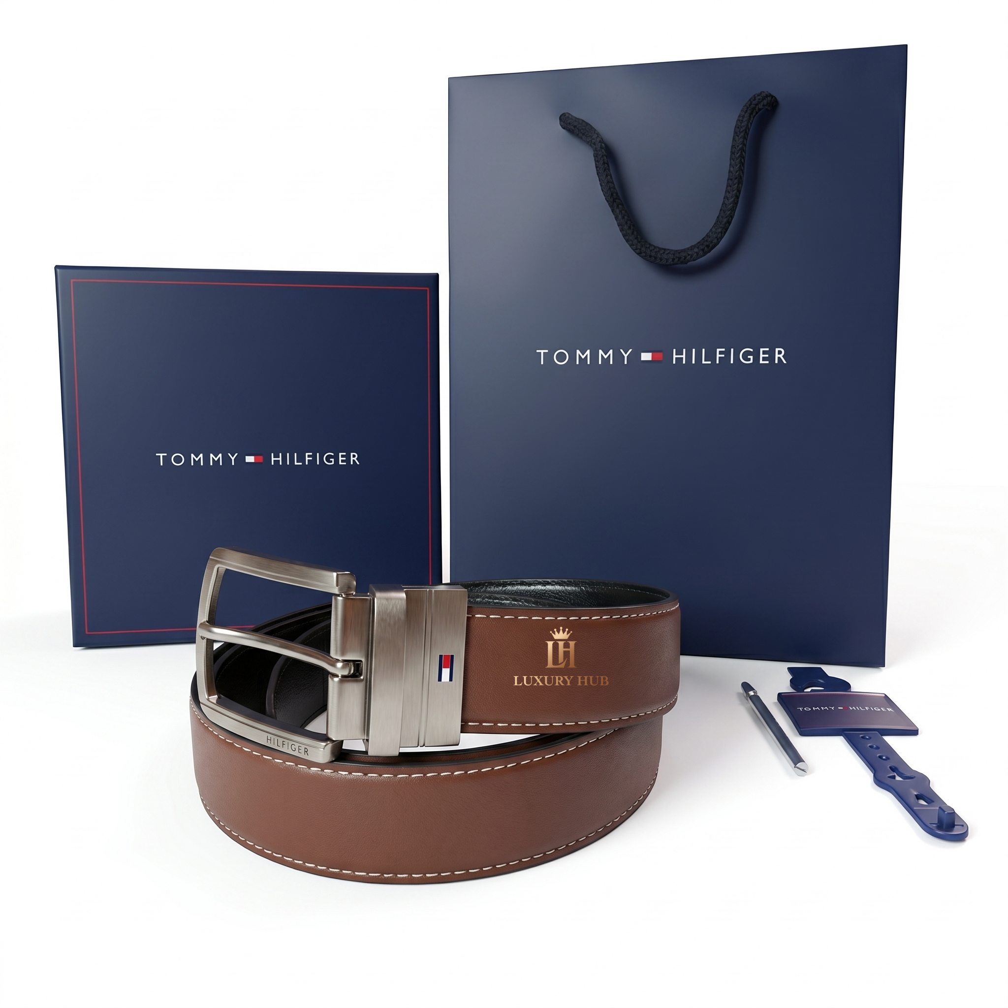 Tommy Hilfiger brown leather belt with silver buckle, packaging box, and shopping bag on a white background.