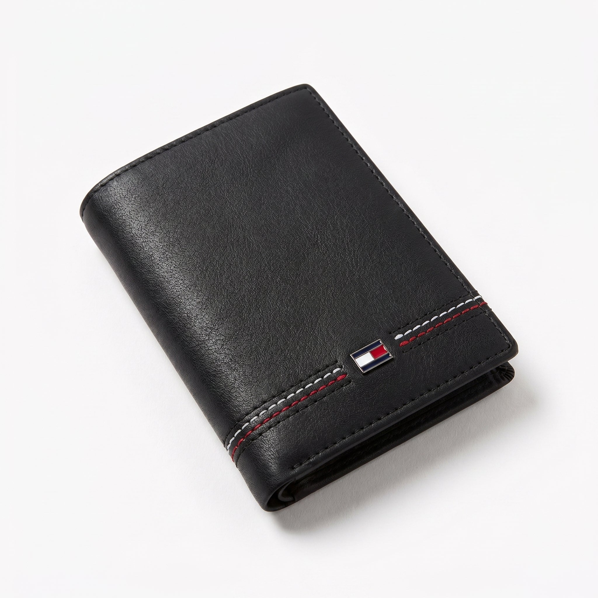 Macro close-up view showing the high-quality smooth leather texture and precision embedded Tommy Hilfiger metal enamel flag logo