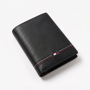 Macro close-up view showing the high-quality smooth leather texture and precision embedded Tommy Hilfiger metal enamel flag logo