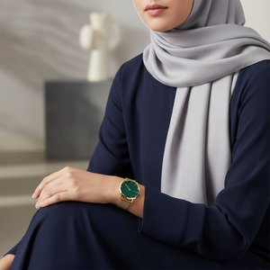 Female model wearing Tommy Hilfiger 1782668 gold green watch with a sophisticated modern outfit
