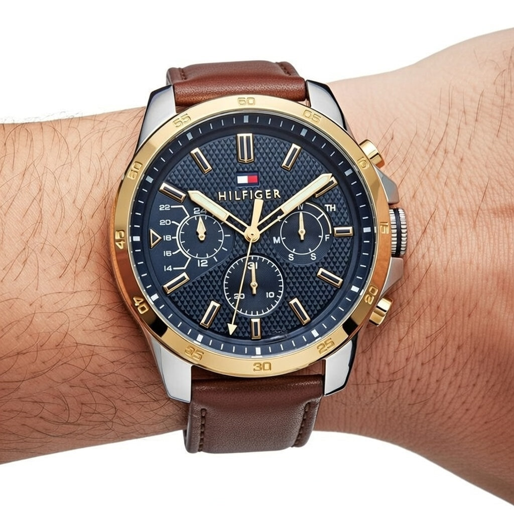 Close up shot of Tommy Hilfiger 1791561 watch on wrist showing the textured blue dial and gold bezel
