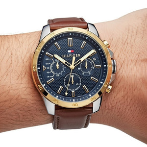 Close up shot of Tommy Hilfiger 1791561 watch on wrist showing the textured blue dial and gold bezel