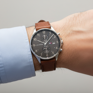 Close up shot of Tommy Hilfiger 1791710 watch on wrist showing the textured brown leather and grey dial