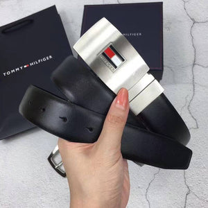 Close up detail of Tommy Hilfiger silver plaque belt buckle with flag logo and embossed genuine leather branding