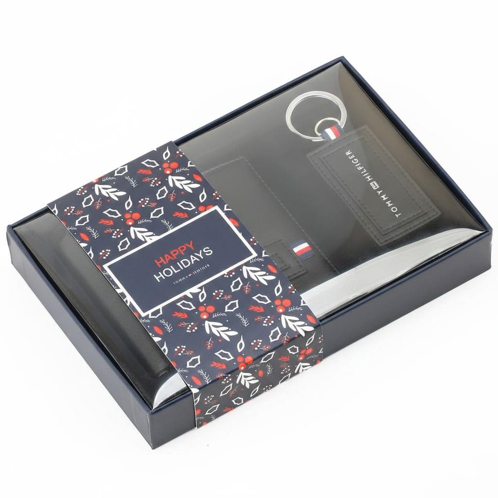 Tommy Hilfiger men's black textured leather wallet featuring a metal flag and Hilfiger lettering, presented inside its original open gift box with an RFID protection band