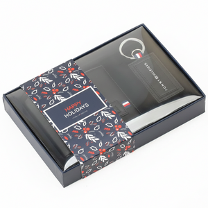 Tommy Hilfiger men's black textured leather wallet featuring a metal flag and Hilfiger lettering, presented inside its original open gift box with an RFID protection band