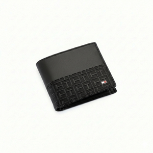 Angled view of Tommy Hilfiger black leather wallet featuring smooth top panel and geometric monogram embossed bottom with flag logo