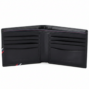 Detailed interior of an open Tommy Hilfiger black leather wallet showing multiple card slots and the "Genuine Leather" embossed stamp