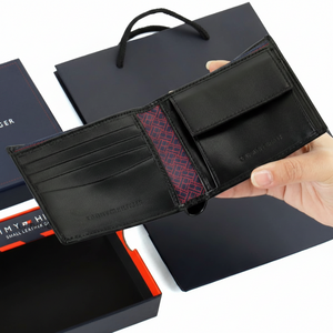 Interior view of Tommy Hilfiger black wallet showing a snap-button coin pocket, card slots, and a unique monogram pattern lining in the center
