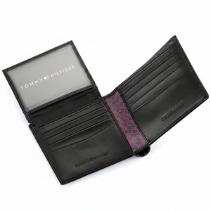 Black leather wallet with red interior lining, featuring Tommy Hilfiger branding.