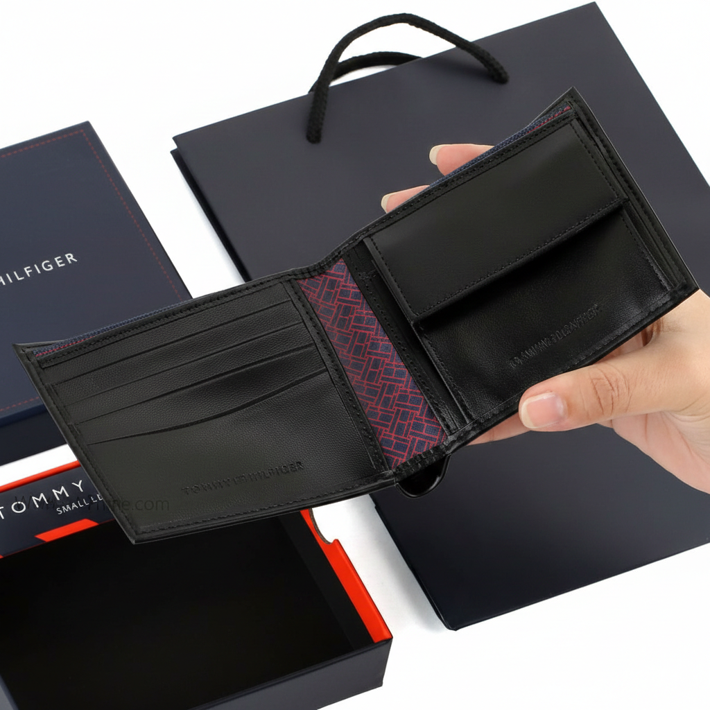 Interior view of the Tommy Hilfiger black leather bifold wallet highlighting the functional coin pocket, card slots, and stylish patterned fabric lining
