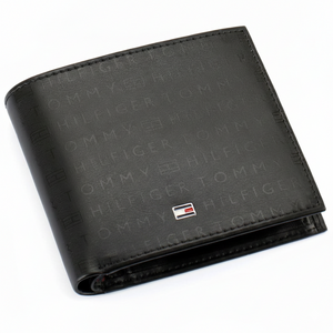 Front view of a Tommy Hilfiger men's black genuine leather bifold wallet featuring an all-over embossed monogram pattern and a silver-toned metal flag logo