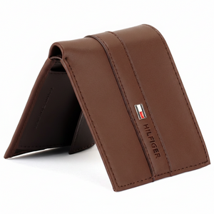 Side perspective of a standing Tommy Hilfiger brown genuine leather bifold wallet highlighting the high-quality stitching and elegant debossed brand name