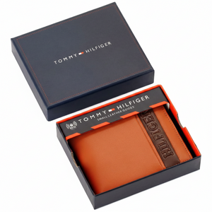 Authentic Tommy Hilfiger men's camel genuine leather bifold wallet with a brown vertical branding stripe, presented in its premium navy gift box