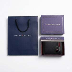 Full luxury presentation of the Tommy Hilfiger mirror original smooth black leather wallet with its matching detachable card case, original gift box, and navy shopping bag