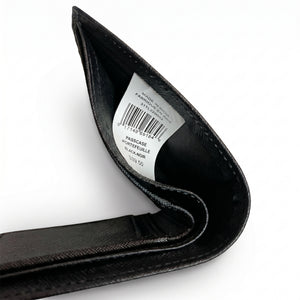 High-angle interior view of the opened Tommy Hilfiger textured leather wallet currency compartment highlighting the original white tracking barcode label and fabric lining