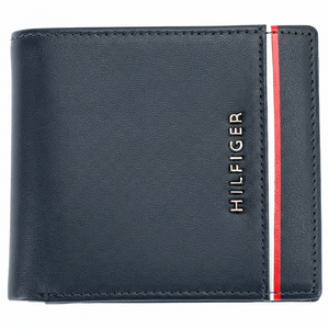 High-detail close-up of the embossed Hilfiger branding and silver metal logo on a navy blue Tommy Hilfiger genuine leather wallet