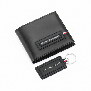 Fully open interior view of a Tommy Hilfiger men's black leather wallet showcasing card slots, a snap-button coin pocket, and a central spine featuring a red and blue 'H' monogram pattern