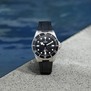 Tudor Pelagos men's automatic dive watch, 42mm titanium case, black dial, black ceramic bezel, black rubber strap – poolside view