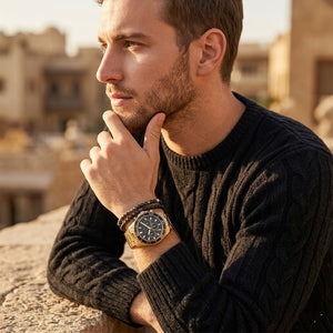 Elegant man wearing Guess Chaser W0170G2 men's quartz battery watch with gold case and luxury gold metal bracelet