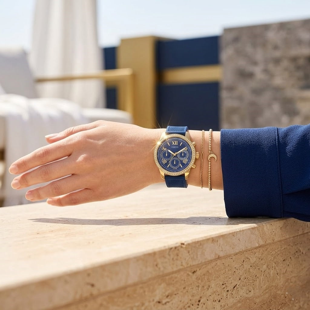 Close up of Guess Sunrise W0616L2 women's multi-function watch (Rose Gold Cushion Case and Navy Blue Rubber Strap variant) on wrist showing deep blue dial with multi-function display and luminous indices