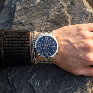 Close up of Guess Hudson W0875G1 men's quartz battery watch on wrist showing clean blue dial and silver roman numerals