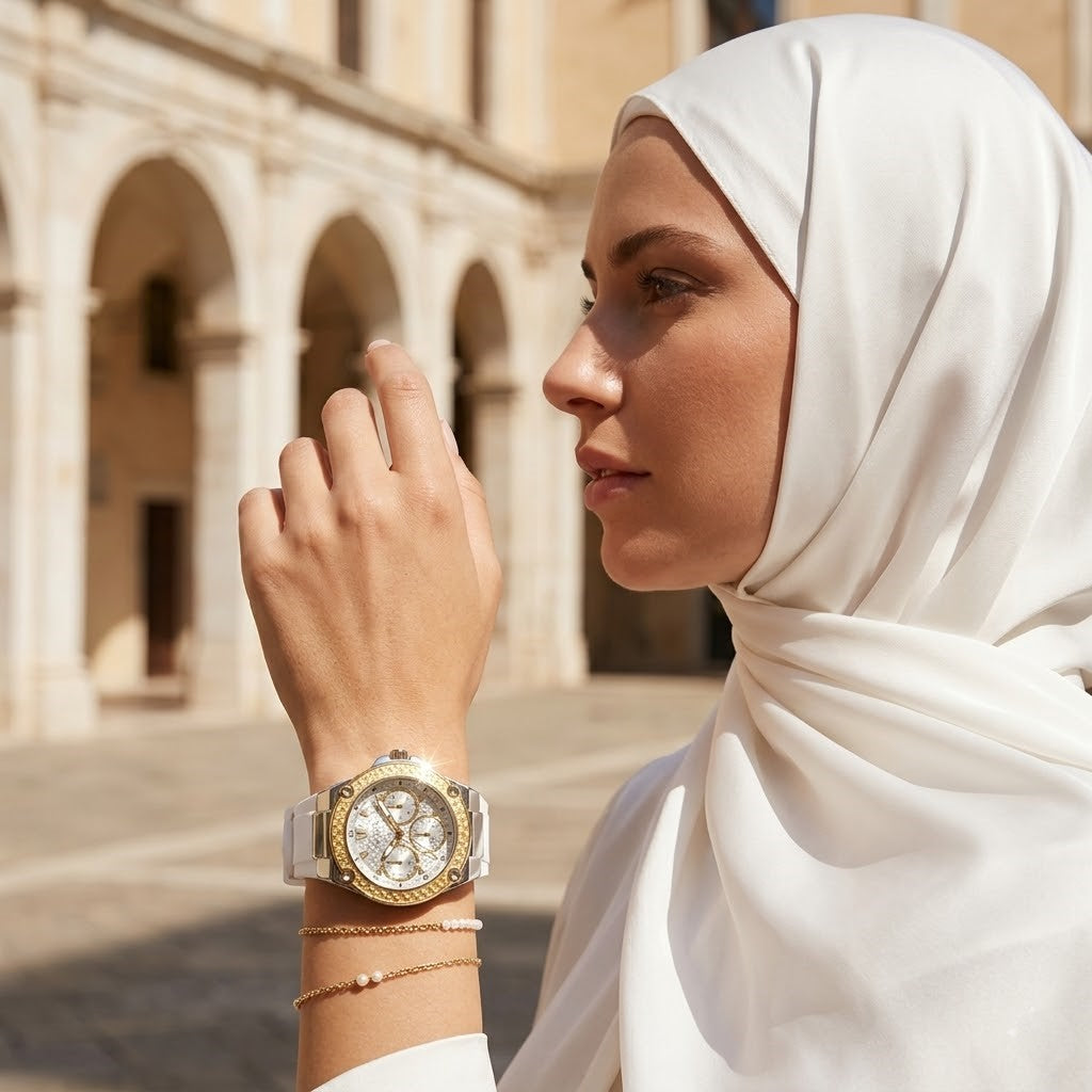 Elegant woman wearing Guess Zena W1094L1 women's quartz battery watch with silver case and luxury white rubber strap