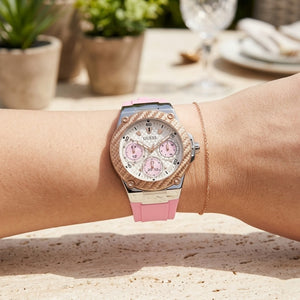 Close up of Guess Zena W1094L4 women's quartz battery watch on wrist showing clean white dial and luxury rose gold bezel
