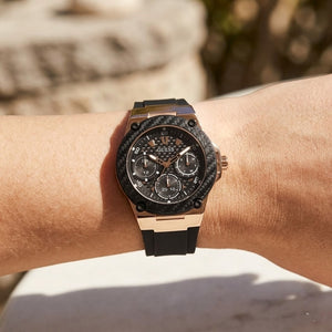 Close up of Guess Zena W1094L6 women's quartz battery watch on wrist showing clean black dial and luxury black bezel