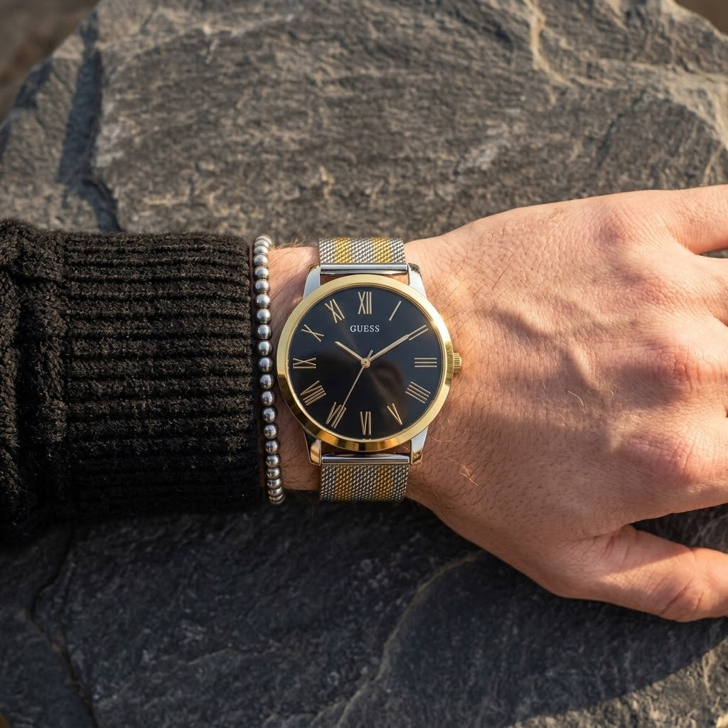 Close up of Guess W1179G2 men's quartz battery watch on wrist showing clean black dial and gold roman numerals