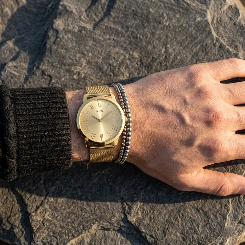 Close up of Guess Richmond W1263G2 men's quartz battery watch on wrist showing clean gold dial and roman numerals