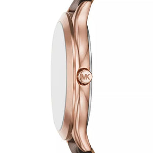 Close-up side view of a Michael Kors watch with a rose gold case, brown leather strap, and a white dial on a white background.